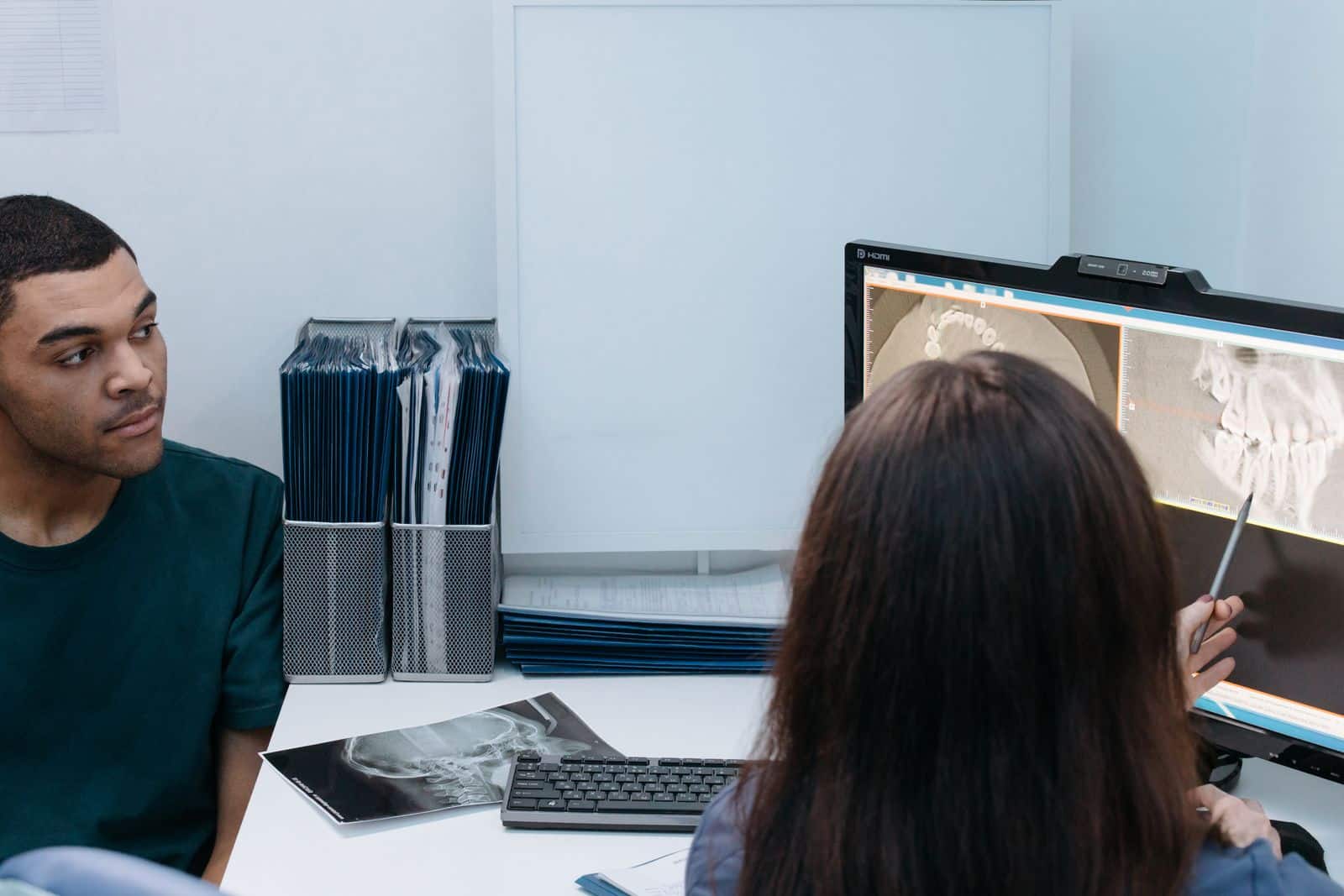English-speaking dentist in Medellin explaining the x-ray and the written plan to a patient